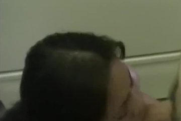 A young couple is filmed in a home video in the kitchen