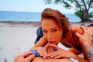 A beautiful brown-haired woman sucks a dick, fucks in a pussy and catches cum on her face in porn on the beach
